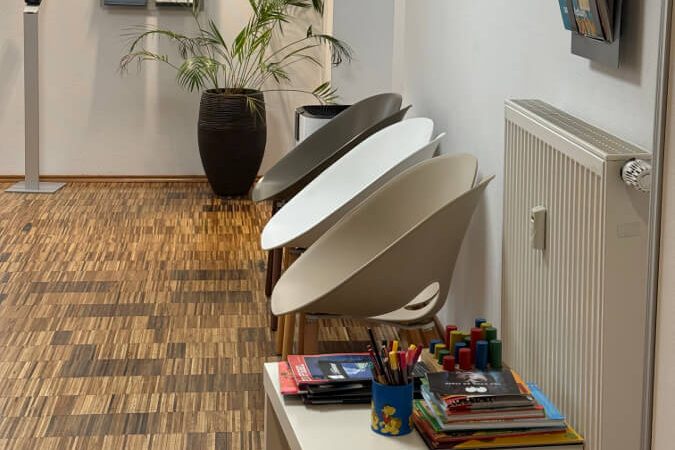 Wartebereich in Physiopraxis mit Stühlen und Kinder-Malsachen